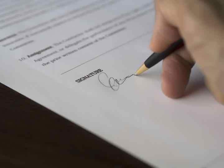 Persona firmando un documento